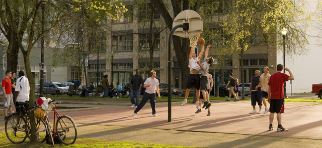Adults playing basketball at outdoor court